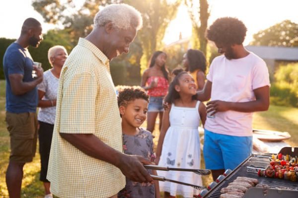 caribbean family grilling on propane bbq at a family event