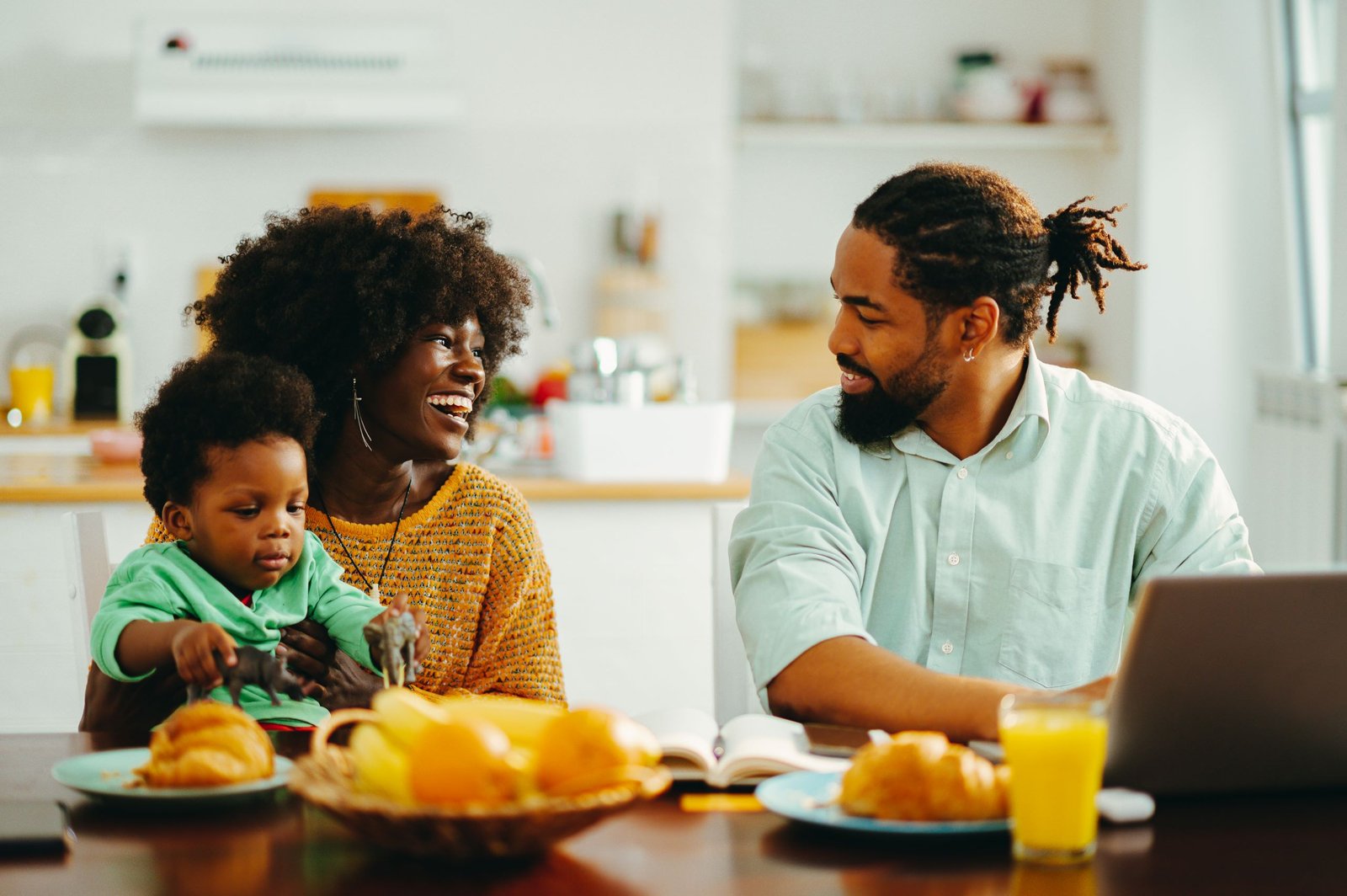 A Cheerful African American Family Sitting At The Breakfast Table